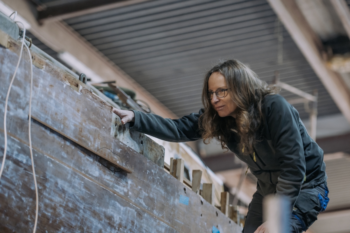 Ada Osińska przyglądająca się burcie jachtu Cleo podczas prac remontowych.