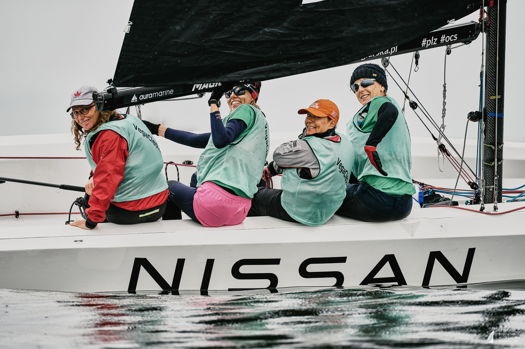 Załoga Vega Cleo Sailing Team siedząca na burcie żaglówki.