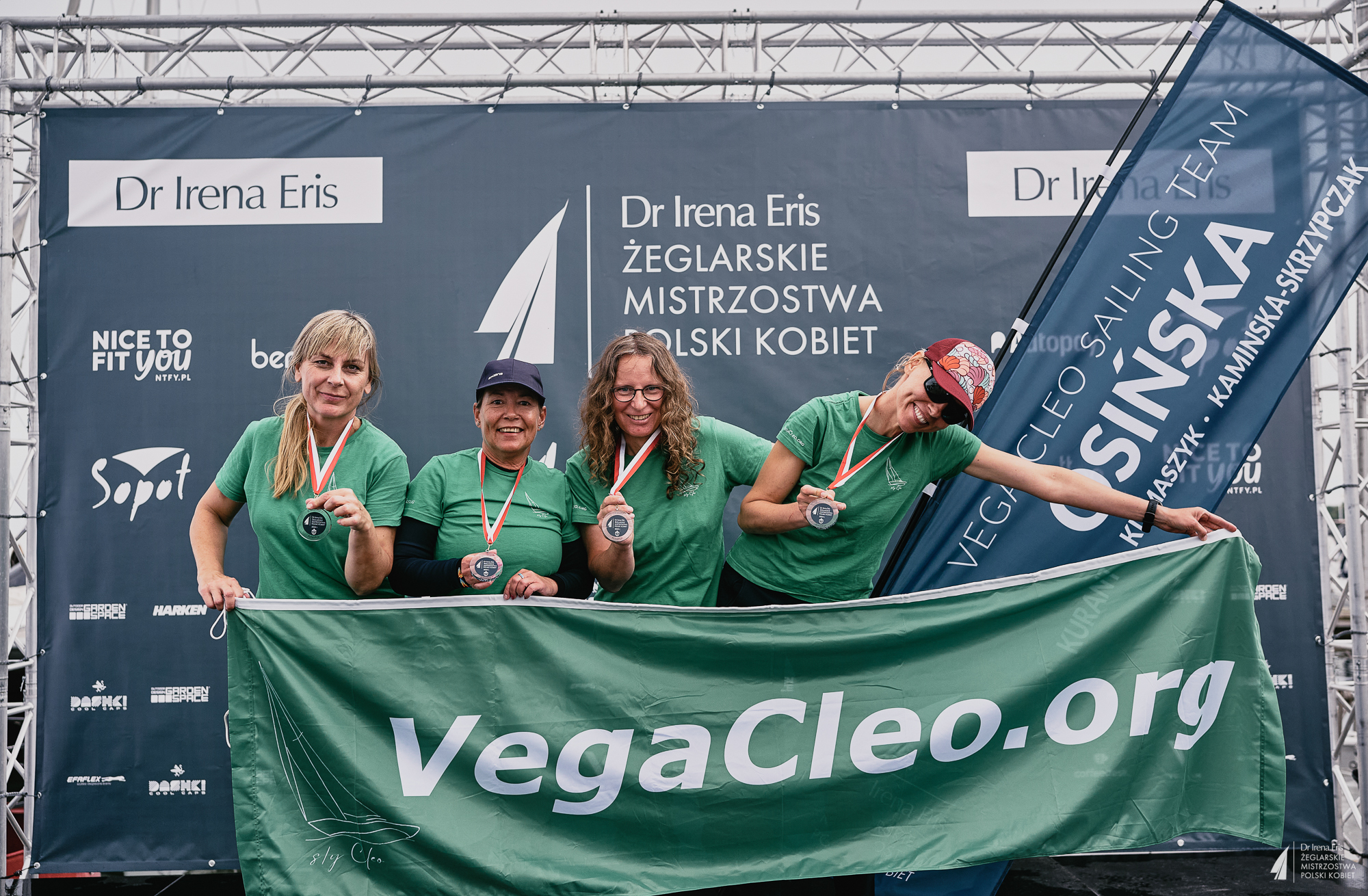 Nasza dumna załoga Vega Cleo Sailing Team z medalami i naszym banerem.